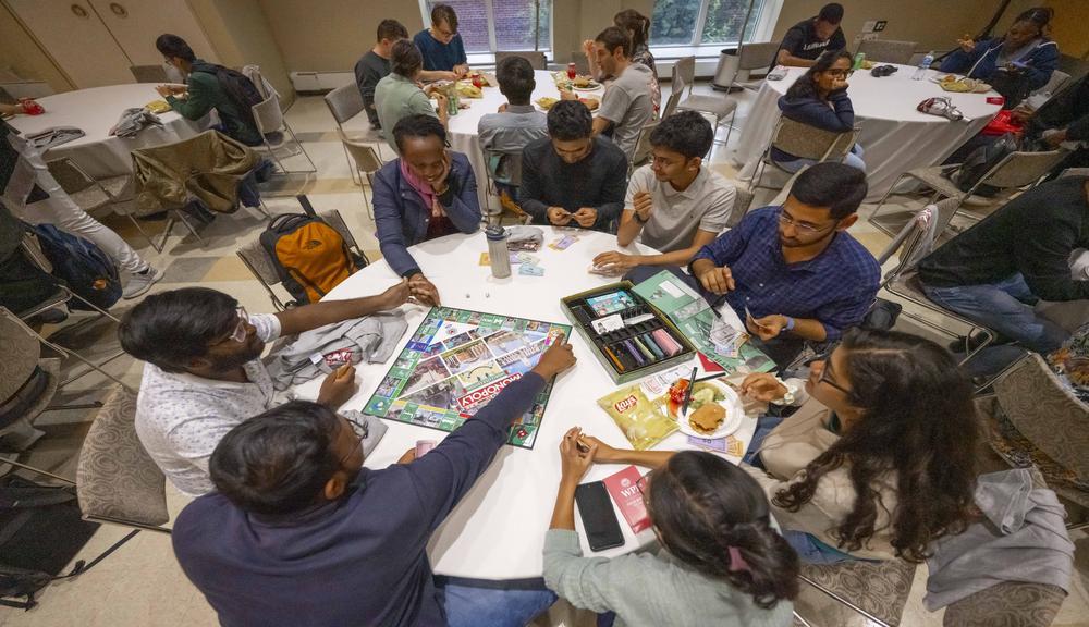 students at a table playing a board game