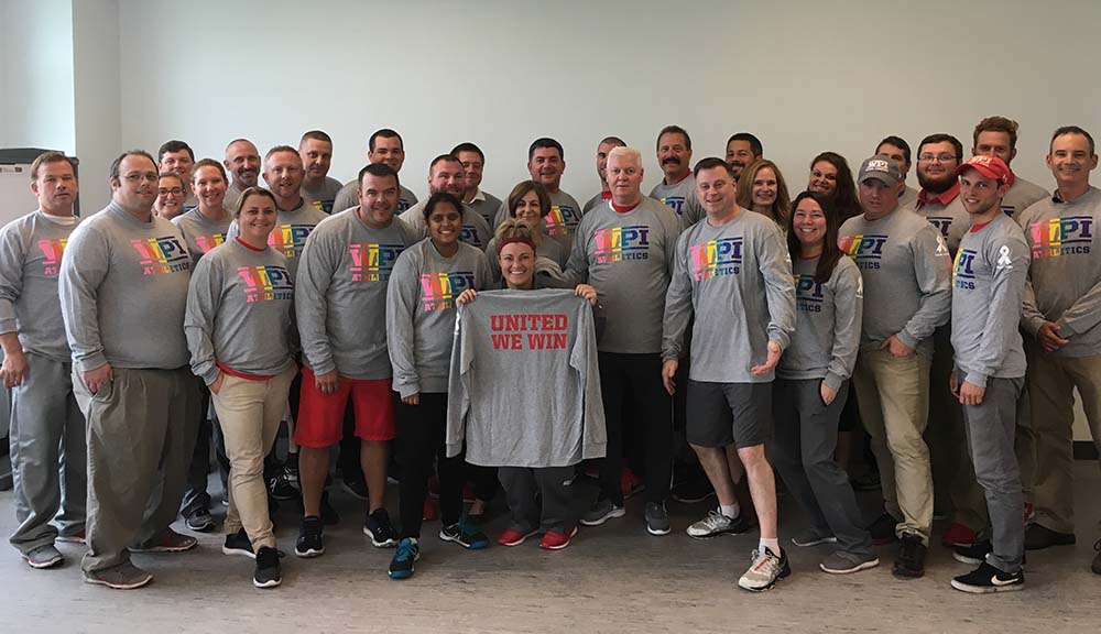Members of the WPI community gather in the Sports & Rec Center in the new WPI Athletics: United We Win shirts.