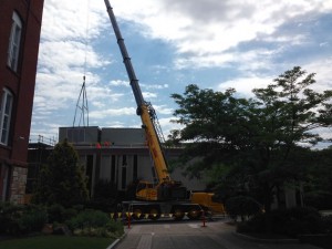 A crane lowers an air handling unit into place on the library roof yesterday.