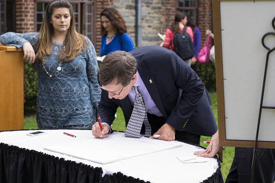 Dean of Engineering David Cyganski was one of several to jot down personal notes to Overström on a matte that will frame a photograph of Boynton Hall, a gift to the outgoing provost.