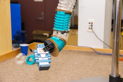 The soft manipulator robot can pick up and place objects.