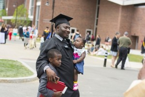 A proud graduate poses for photos with young family members.