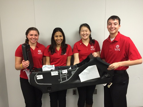 WPI students Kate Piotrowicz, Michelle Acevedo, Dulguun Gantulga and Keith Guay hold up a prototype of a BMW center car console they designed for the competition.