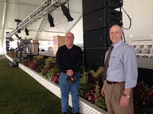 Terry Pellerin and Greg Snoddy stand near the front of the stage as lighting and sound equipment are installed.