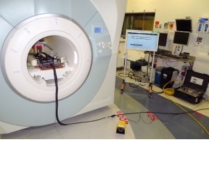 From left, the robot inside the MRI unit; the foot pedal used to activate the robot; a screen that displays its status, and (on floor) the robot controller.