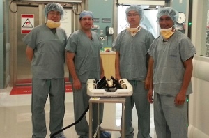 Fischer, second from left, and, from left, PhD candidates Weijian Shang, Gang Li, and Nirav Patel, with the MRI-compatible robot.