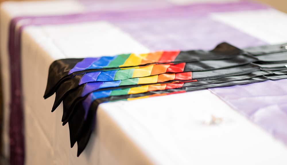 A closeup of rainbow commencement regalia.
