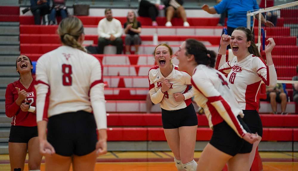 Members of the volleyball team celebrate on the court.