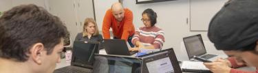 Prof Hektor Kashuri working with students in an active learning classroom.