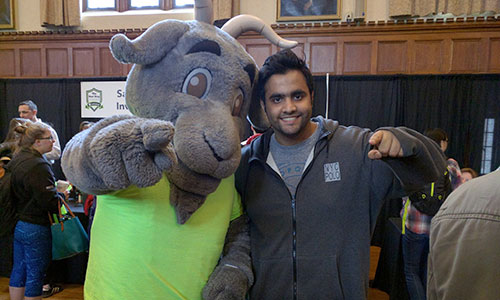 WPI student standing with the mascot Gompei the Goat alt