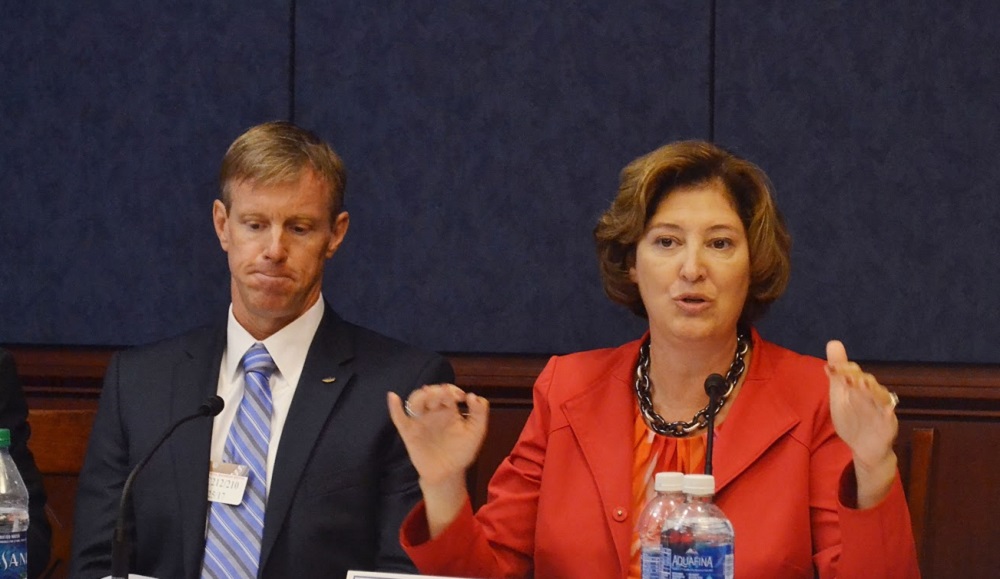 President Leshin in discussion on the panel. She is wearing a reddish-orange shirt and blazer, and her hands are raised in front of her.