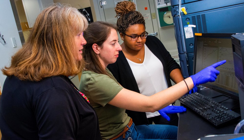 From left, Susan Roberts, PhD candidate Michelle McKee, and master’s candidate Lexi Crowell analyze a sample from a Pacific yew cell culture using ultra-performance liquid chromatography.