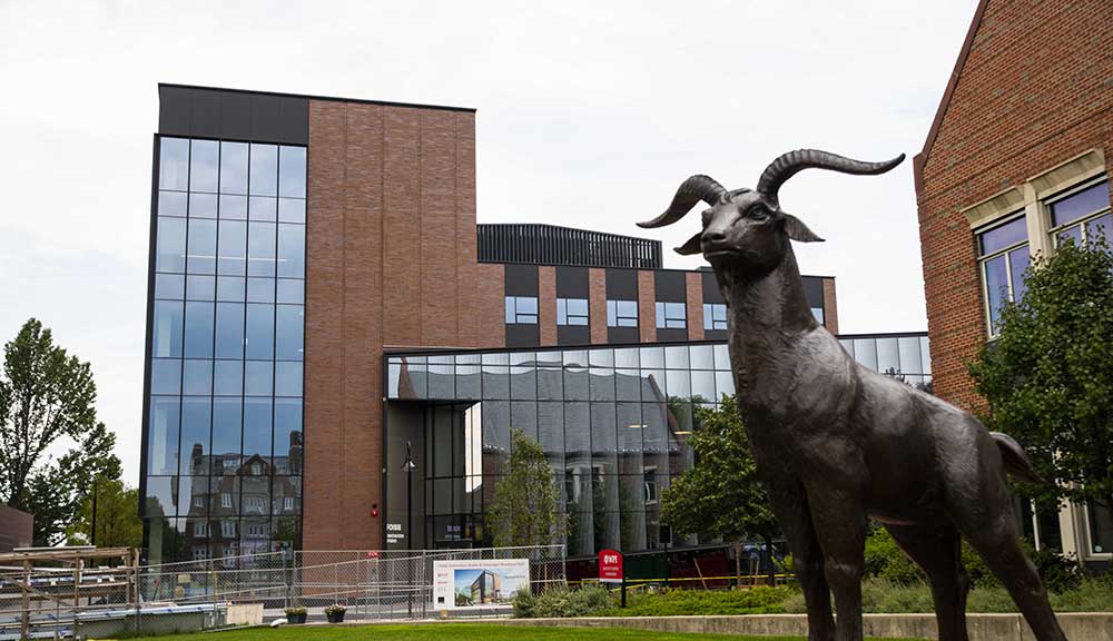 A shot of the nearly completed Foisie Innovation Studio from the Quad, with the Proud Goat statue in the foreground.