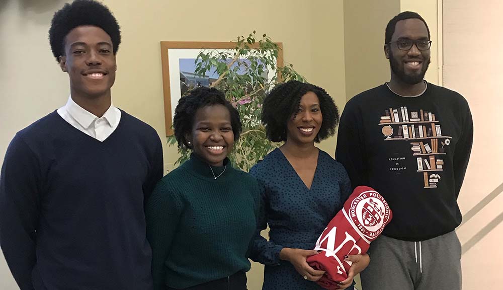 Four attendees gather together and smile at WPI's Black History Month Dinner.