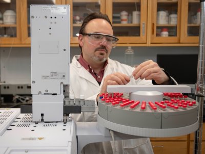 Timko inserts samples of isobutanol into a gas chromatography instrument for chemical analysis ​ ​   ​ alt