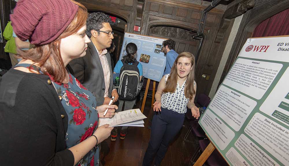 A student explains her work to Project Presentation Day attendees.