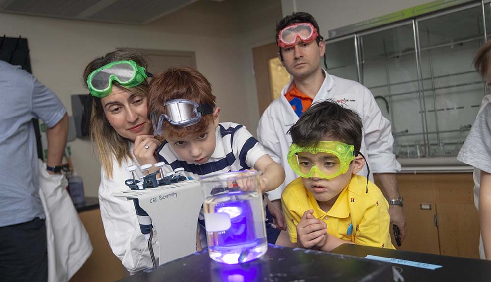 Attendees don safety goggles as they work on an experiment in one of WPI's labs.