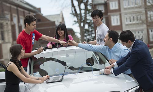 Professor and students working on autonomous car.