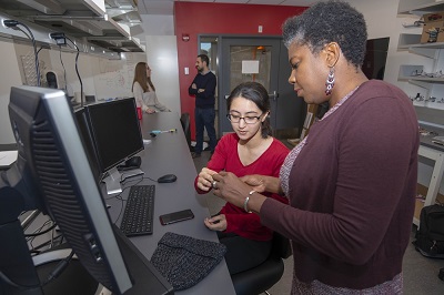 Professor Suzanne Weekes with a student in a robotics lab. alt