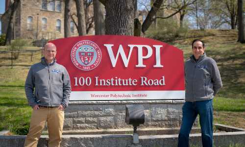 Tim Loew and Monty Sharma stand in front of the WPI sign on Institute Road.