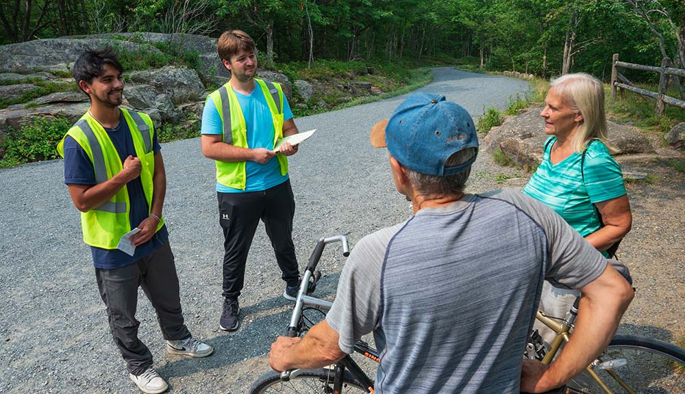 Two students interview visitors to Acadia National Park.