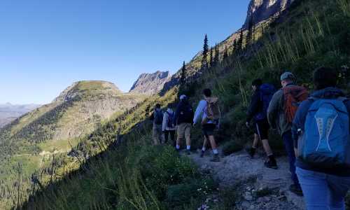 A group of students hike along a trail in Glacier National Park.