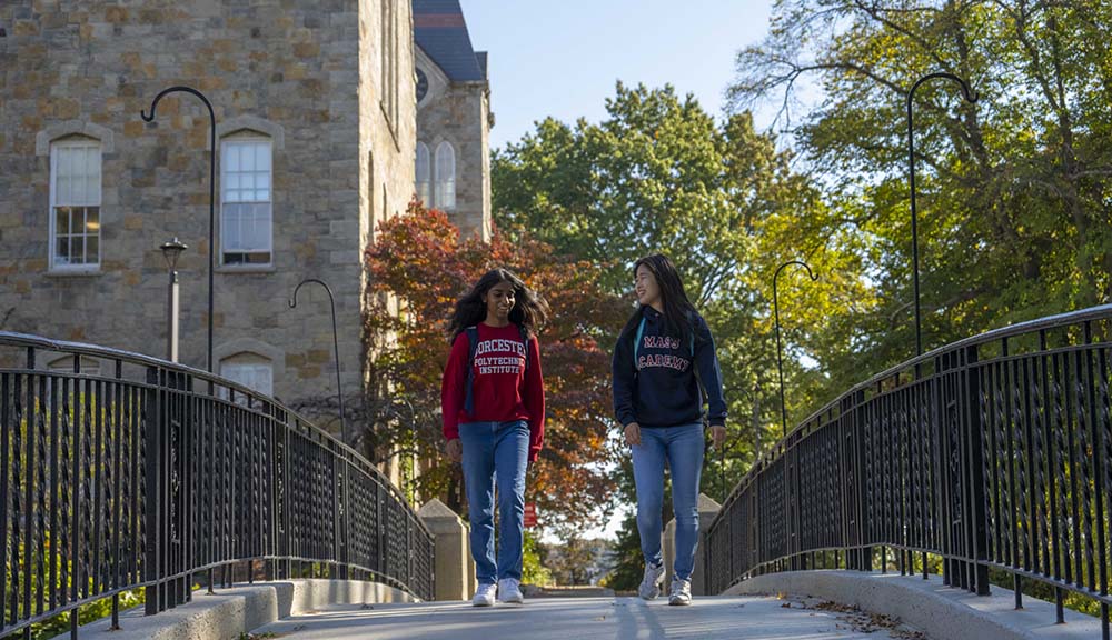 Two Mass Academy students smile and laugh while walking across Earle Bridge.