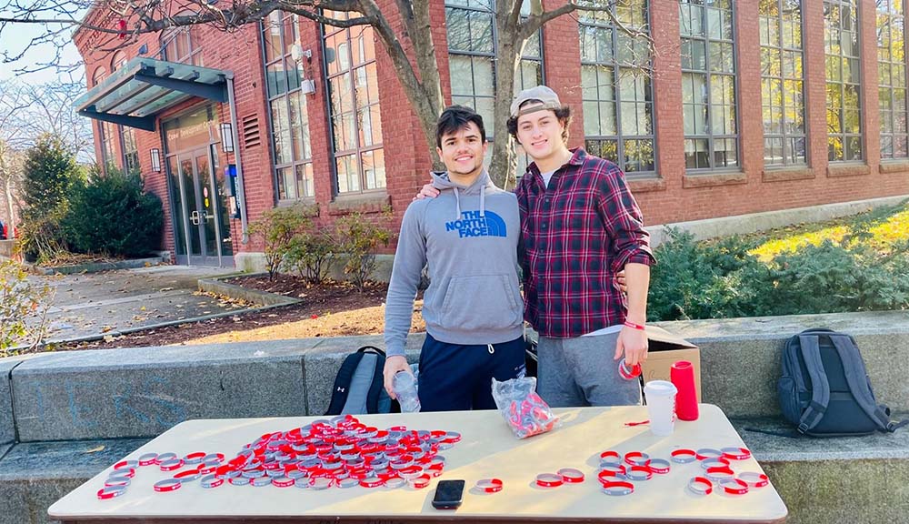 Two students sell bracelets by the fountain to raise money for suicide prevention.