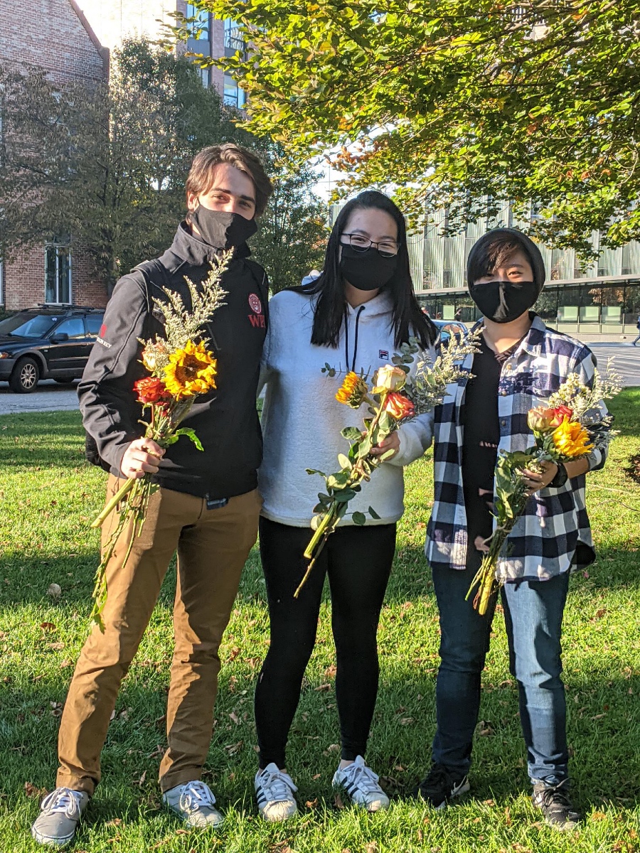 Students posing together with flowers.