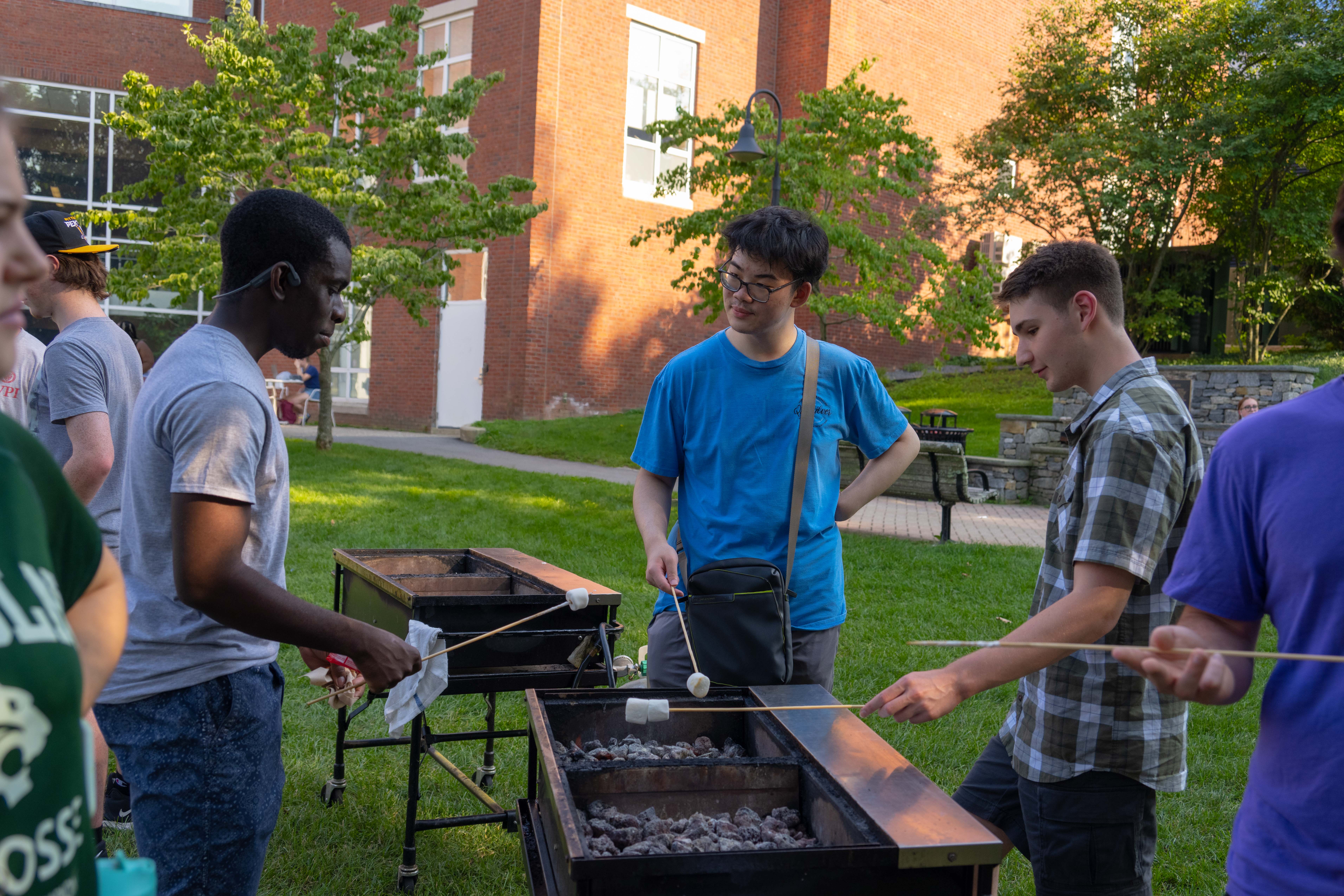 students roasting marshmallows over a grill