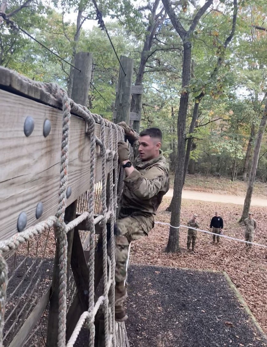 Cadet climbing a rope obstacle
