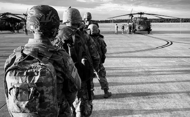 cadets standing in line in front of a helicopter