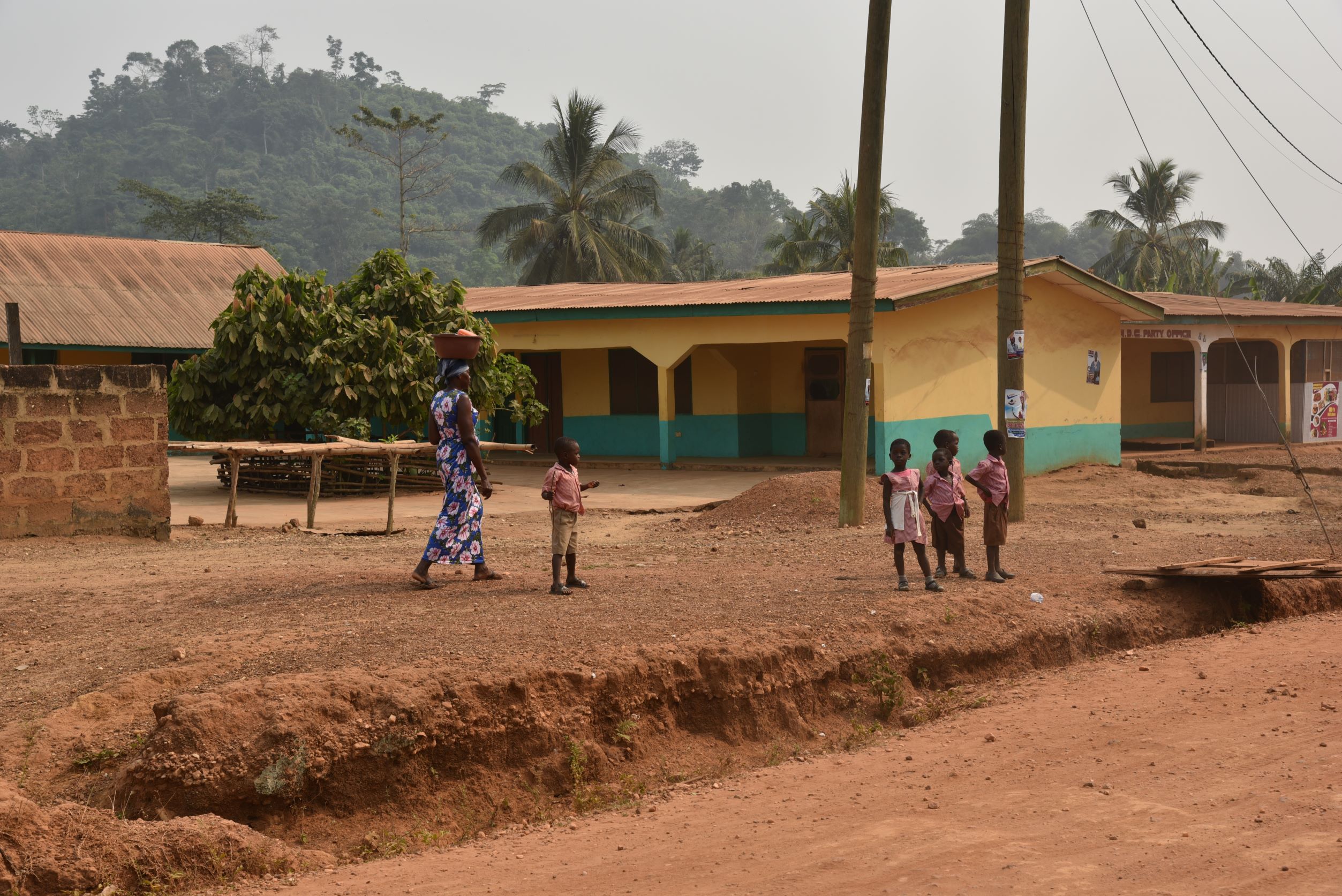 Woman and children walking in Dwenase region of Ghana alt