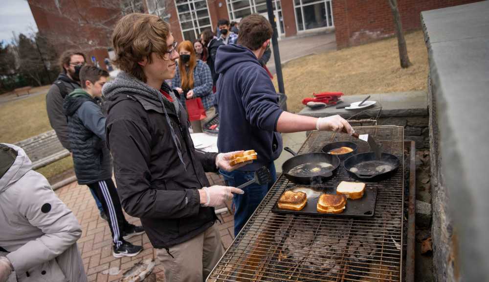 Members of the Cooking Club make grilled cheeses outside of the Campus Center.