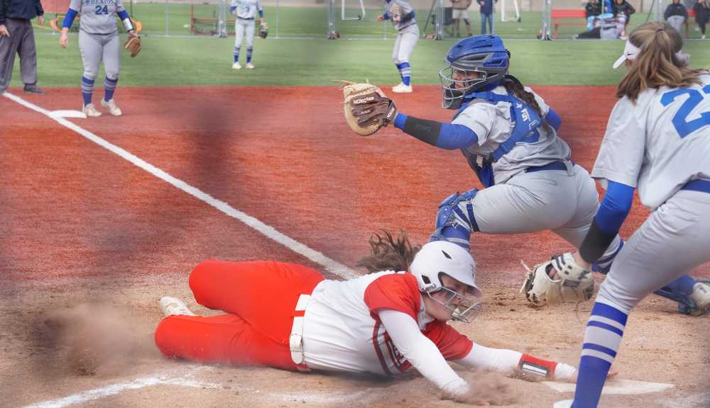 A member of the WPI softball team slides into home plate during a game.