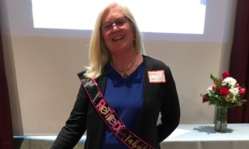 Martha celebrating retirement and wearing a sash