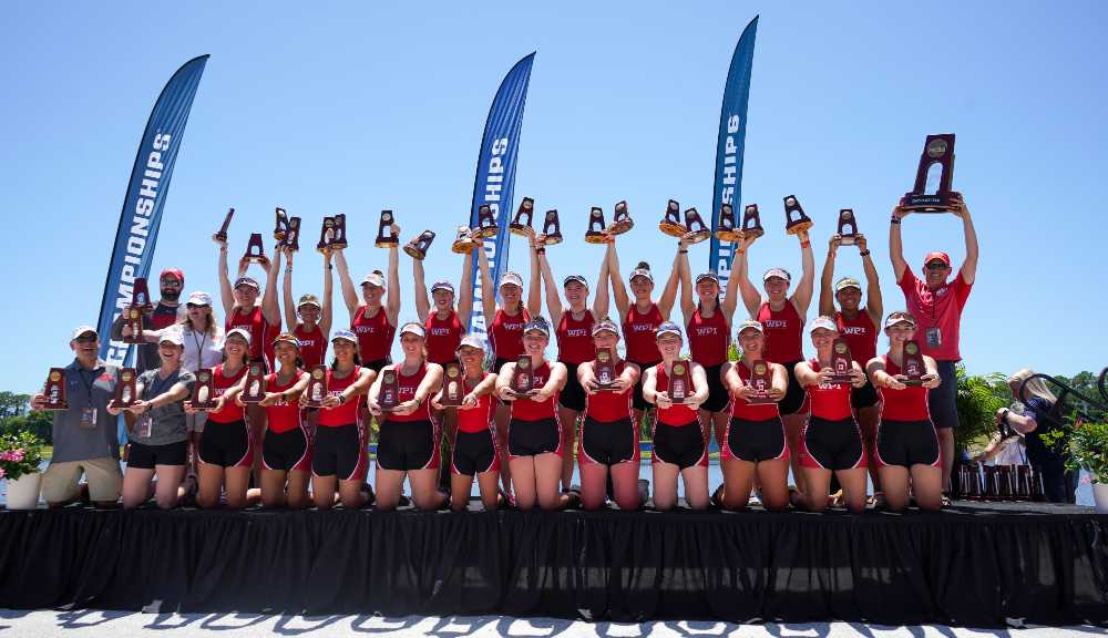 Members of the 2022 Women's Rowing team raise their championship trophies.