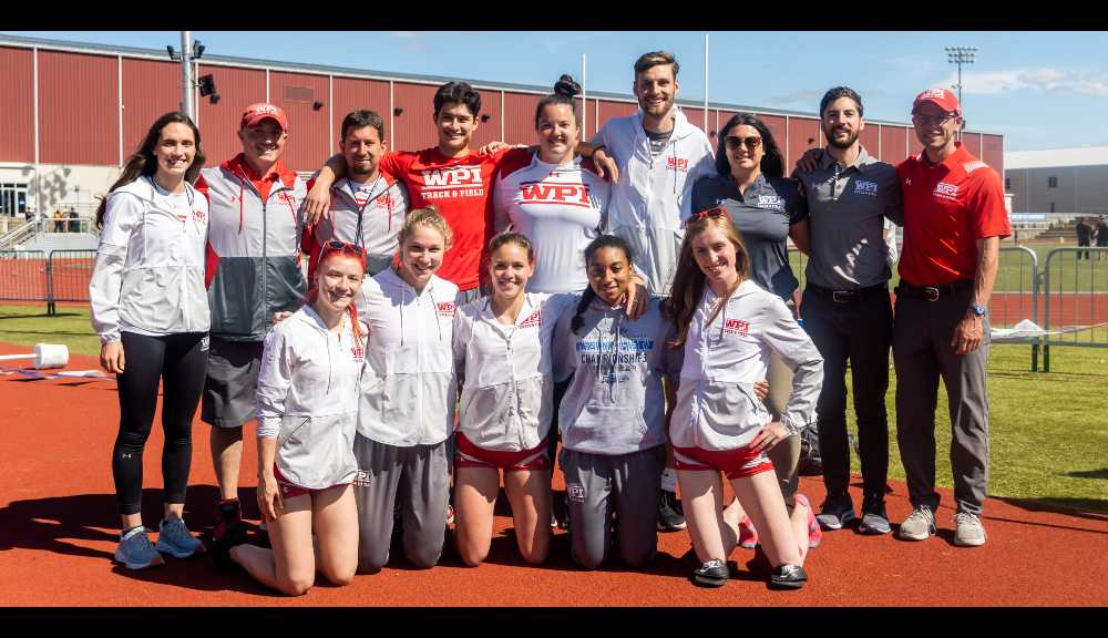 Members of the Track and Field teams smile for a photo on the track.