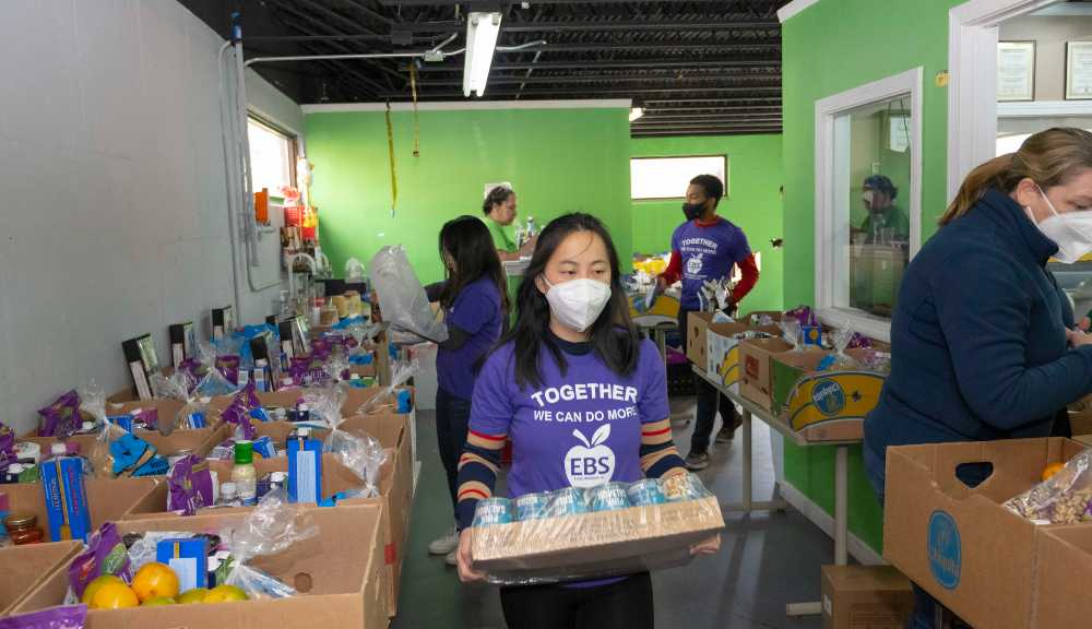 A student carries food through El Buen Samaritano food pantry for delivery.