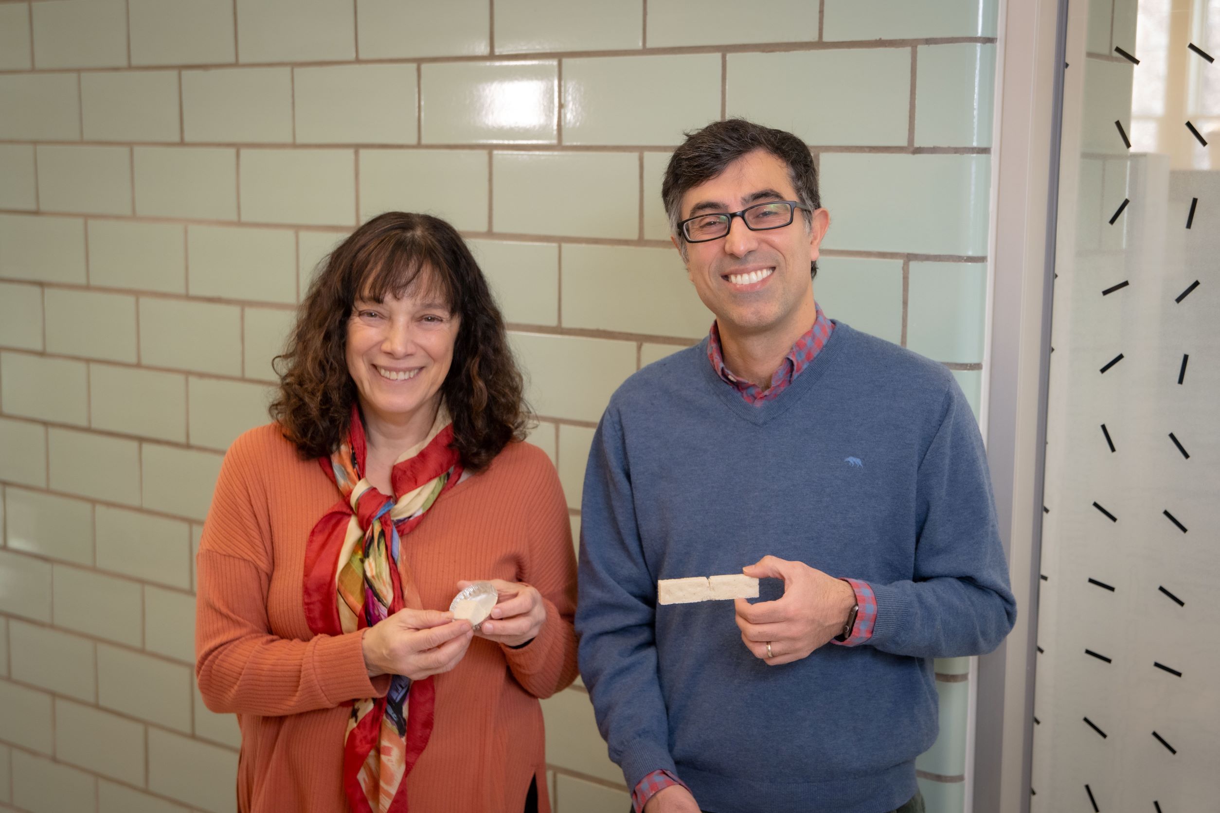 WPI researchers Suzanne Scarlata and Nima Rahbar hold pieces of their sustainable construction material