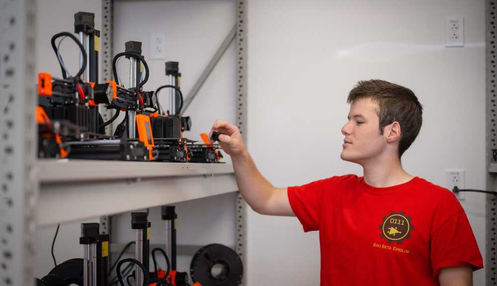 A student observes the XRP robots on a shelf.