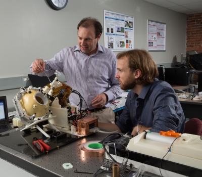 Fischer, left, and research scientist Christopher Nycz with an MRI-compatible robot for treating brain tumors