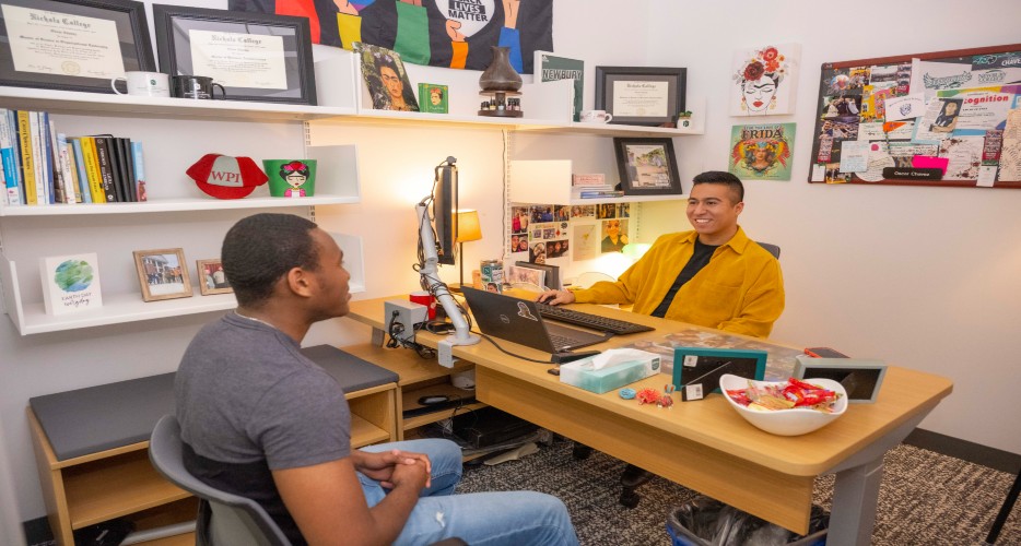 An academic advisor meets with a student in their office.