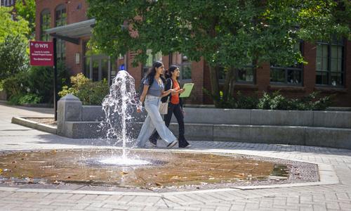 students walking by the fountain