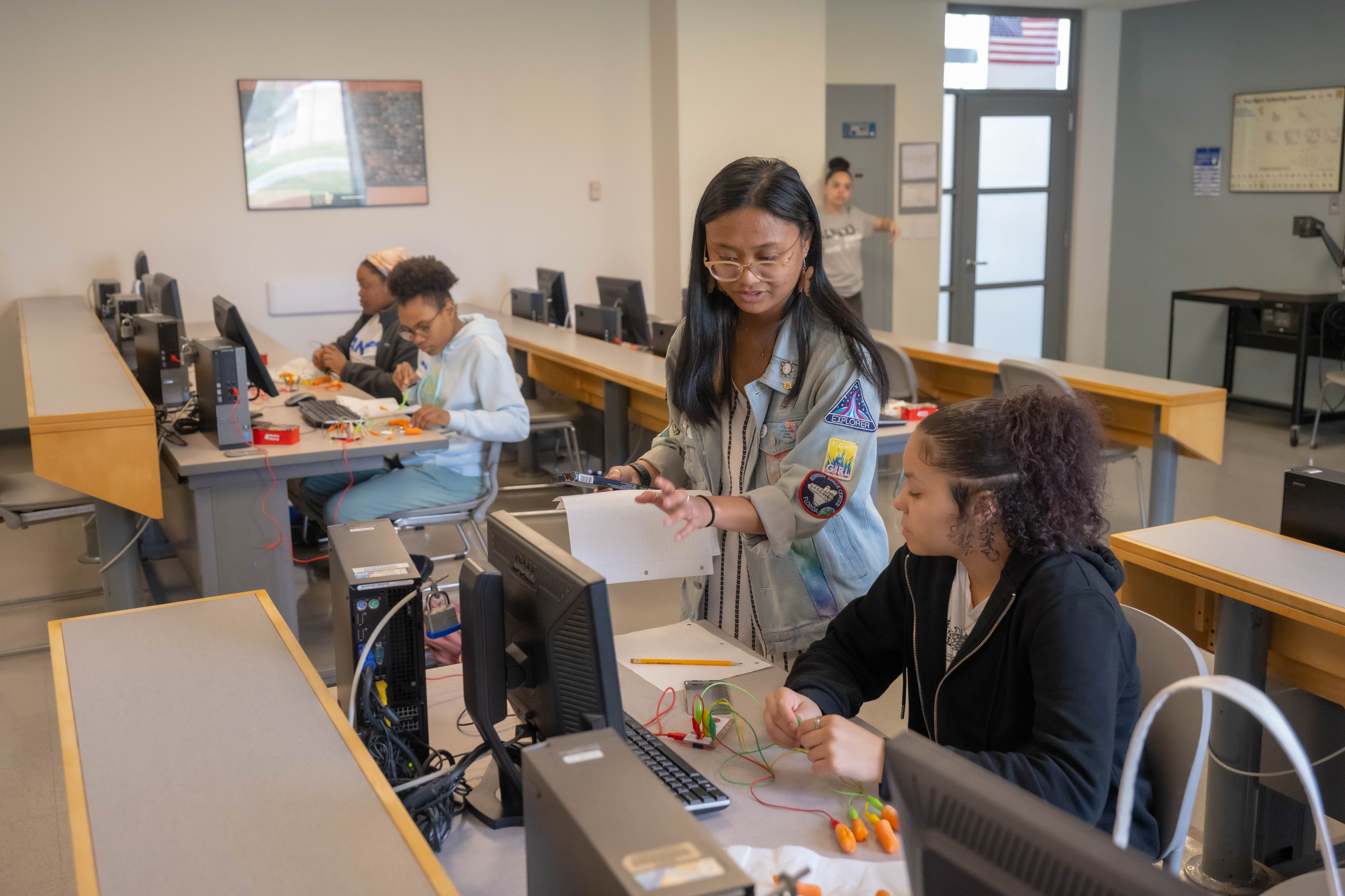 WPI student Regina Valencia teaches the basics of electrical circuits to a Latino Education Institute middle school students using Makey Makey to make music during the AVANZA STEM Expo 2023.