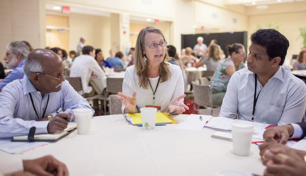 seated woman speaking with man on either side looking at her