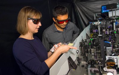 Lyubov Titova and Pratap Rao examine the terahertz  spectroscopy technology in Titova’s Terahertz Physics  Lab that is being used to measure the behavior of  charges within new, more efficient materials that Rao  and his team are developing for solar photovoltaic cells.
