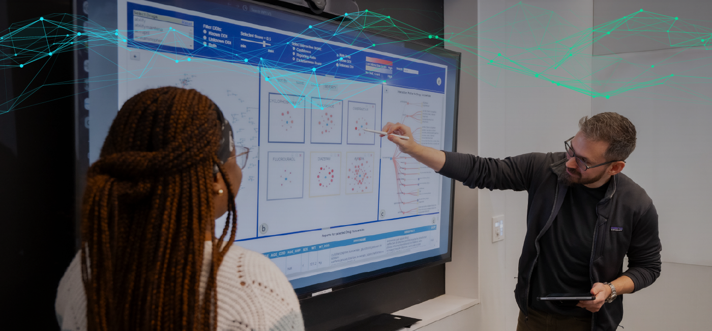 Professor pointing to data sets on a digital screen