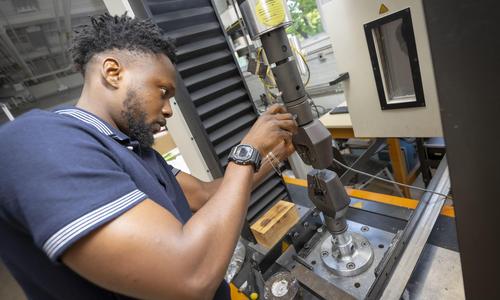 student configures machinery in laboratory