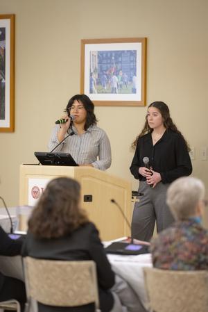 Students speaking at a podium presenting their project work.